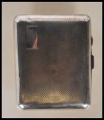 A circa 1930's Art Deco silver cigarette case of curved rectangular form having engine turned