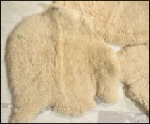 A collection of three 20th Century retro vintage sheepskin fleece floor rug carpet mats each natural
