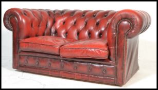 A 20th Century Oxblood leather upholstered chesterfield two seater sofa, having buttoned rounded