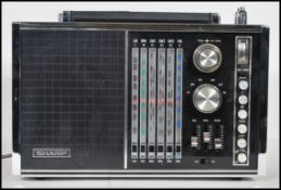 A vintage Sharp made FV-1800 6 Band portable radio. Black, with silver knobs and switches to