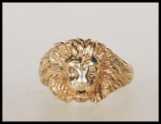 An English hallmarked 9ct gold lion mask ring having pierced eyes and mouth. Assay marks for London.