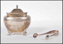 A silver hallmarked sugar pot having a twist decorated finial atop the hinged lid opening to