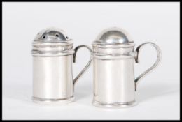 A pair of stamped 925 silver miniature salt and pepper condiments in the form of handled castores