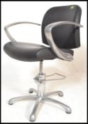 A pump action chrome and black leather salon barbers desk chair having chromed boomerang arm