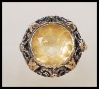 A vintage 18ct yellow gold ring having a central faceted cut oval Citrine set to a decorative