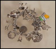 A silver heart lock charm bracelet having an assortment of charms to include hand, shire horse,