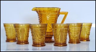 An early 20th Century Art Deco pressed amber glass lemonade set, comprising lemonade jug and a set
