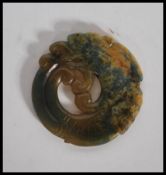 A 20th Century Chinese carved jade pendant medallion in the form of a dragon having carved scale and