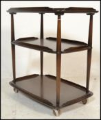 A vintage mid 20th Century Ercol three tier trolley, with a raised gallery on turned supports
