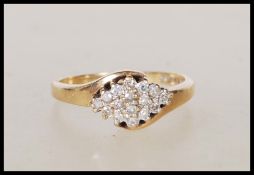 A 9ct gold English hallmarked diamond cluster ring with a crossover design. Hallmarked Sheffield