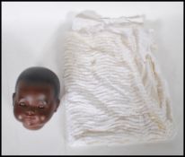 A vintage German made ceramic black dolls head having articulated glass eyes. Back of the neck