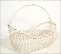 A vintage 20th Century wicker moses / laundry basket being painted in white, of large proportions