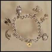 A silver hallmarked heart lock charm bracelet having six charms including a viking ship, pair of