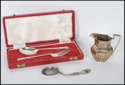 A collection of silver items to include a silver hallmarked fork and spoon set by Oliver & Bower