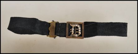 A 19th Century Victorian mourning bracelet constructed from a black ribbon with a stamped 9ct gold