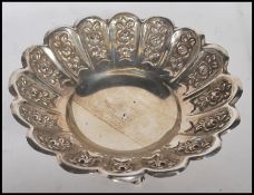 A stamped 800 silver dressing table trinket bowl having a scalloped rim with repousse floral