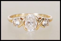 A stamped 585 14ct gold ring set with a central oval cut white stone flanked by two round cut