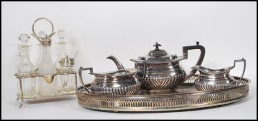An early 20th Century three piece silver plated tea service set to a gallery twin handled silver