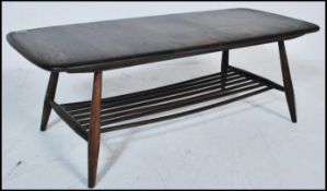 A retro 20th Century Ercol Windsor pattern beech and elm coffee table raised on tapering supports