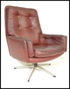 A vintage retro 20th Century button back swivel armchair, upholstered in an oxblood leatherette
