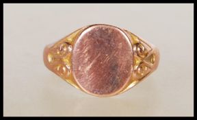 A hallmarked 9ct gold signet ring having an oval head with scrolled shoulders. Hallmarked Birmingham