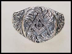 A stamped 925 silver gentlemans ring having the masonic symbol centre with floral and scroll