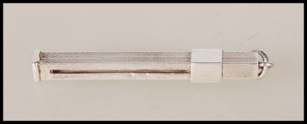 A silver hallmarked propelling toothpick of square rectangular form having engine turne decoration