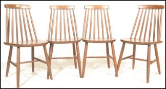 A group of four vintage mid 20th Century Ercol style spindle back dining chairs, raised on turned