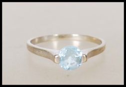 A 9ct white gold English hallmarked ladies ring set with a round cut blue stone. Assay marked for