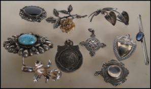 A collection of vintage silver and silver white metal brooches to include a stamped silver rose