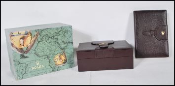 A vintage Rolex box upholstered in burgundy leather with a buckle design to the top, the interior