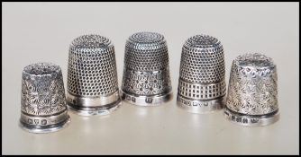 A group of five silver hallmarked thimbles dating from the 20th Century, each having engraved