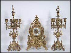 A 20th century French brass clock garniture, ornately decorated case moulded with scrolled leafage