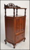 An early 20th Century Edwardian oak music cabinet of upright form having a Art Nouveau pierced