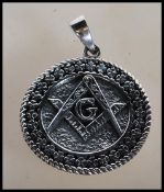 A stamped 925 silver necklace pendant of round form having a geometric pattern border around the