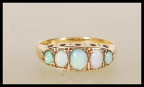 A 20th Century stamped 18ct gold ring set with five graduating oval opal cabochons. Weight 2.4g.