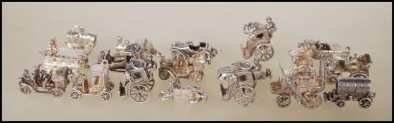 A collection of 18 silver transport related charms to include wagons, cars, carriages, steam train