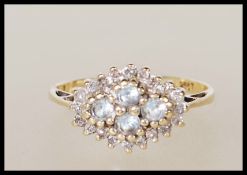 A hallmarked 9ct gold diamond cluster ring having four larger stones to the centre surrounded by