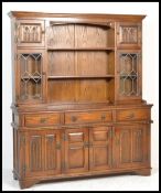 An Old Charm oak Linenfold dresser and rack, the rack with two lead glazed doors and two plate