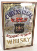 A 20th Century pub advertising mirror for Scottish Chivas Regal. The mirror with scrolling borders