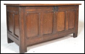 A 17th / 18th Century country oak coffer being raised on square stile legs with four section panel