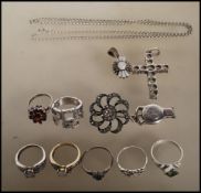 A collection of silver jewellery to include seven rings of differing designs including a red stone