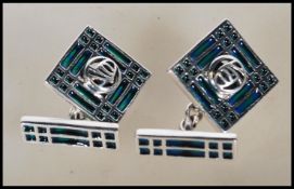 A pair of stamped 925 silver and enamel cufflinks of square form with central pierced decoration.