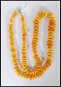 A vintage Chinese amber / amber type necklace with small bead spacers having yellow metal lobster