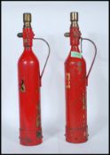 A pair of vintage 1950's fire extinguishers of tall cylindrical form having applied gold labels