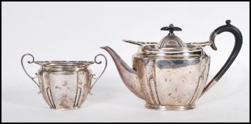 An early 20th Century Edwardian silver hallmarked part tea service, the teapot with ebonised