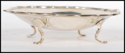 A silver hallmarked pin dish, scalloped rim raised on four pad feet, Sheffield assay mark, dating to