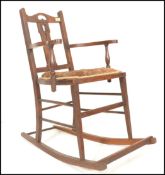 A 19th Century Georgian oak peg joint elbow rocking chair having a tulip design pierced decoration