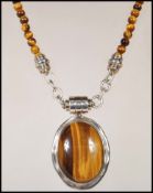 A stamped 925 silver and tiger's eye necklace pendant having magnetic clasp on tigers eye beaded