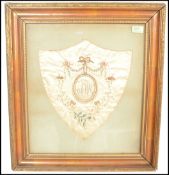 An early / mid 19th Century silk embroidery panel sampler having a central circular panel